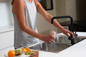 woman getting filtered drinking tap water